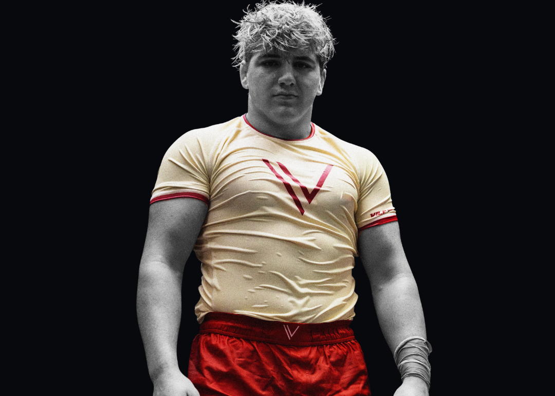 Person wearing a beige shirt with a red 'V' logo and red shorts on a black background, with text about Claudio Margione and Vile Vortices Athlete.